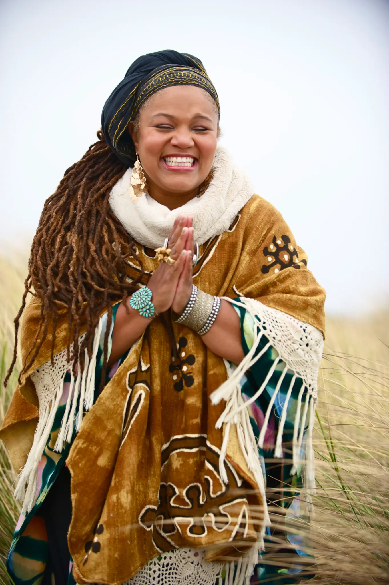 Amikaeyla in prayer hands gesture, golden ceremonial attire