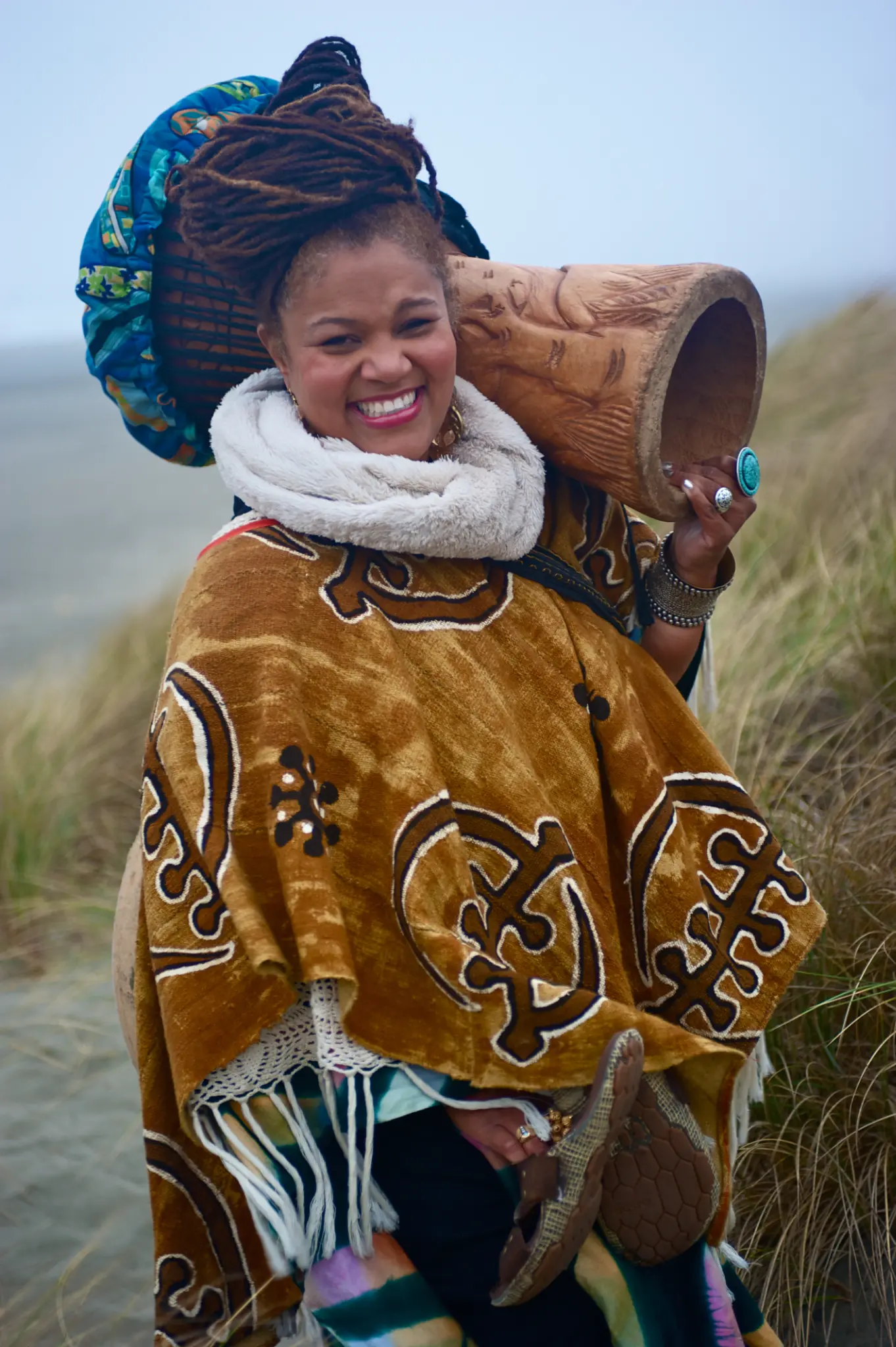 Amikaeyla holding carved drum outdoors
