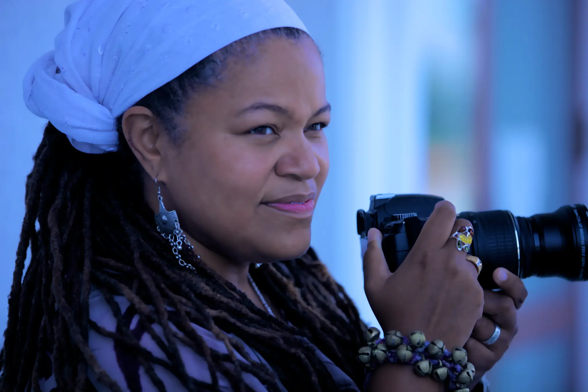 Amikaeyla with camera and white flower headwrap